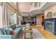 Sun-filled living room with hardwood floors, tall windows, and views into the modern black kitchen at 6614 W Gould Dr, Littleton, CO 80123