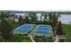 Aerial view of well-maintained tennis courts with lush landscaping near the lake, a great amenity for recreation at 6614 W Gould Dr, Littleton, CO 80123
