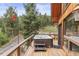 Deck with hot tub offers serene views of wooded surroundings for relaxation at 12191 Tecumseh Trl, Conifer, CO 80433