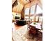 Open-concept living and dining area with a stone fireplace, wood-clad vaulted ceiling, and large windows at 12191 Tecumseh Trl, Conifer, CO 80433