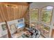 Aerial view of a living room featuring a stone fireplace, wood ceiling, natural light and leather seating at 12191 Tecumseh Trl, Conifer, CO 80433