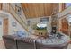 Living room featuring a stone fireplace, vaulted ceiling, wooden staircase and a comfortable, oversized leather couch at 12191 Tecumseh Trl, Conifer, CO 80433