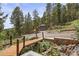 Property features a pond with bridge. Wood sheds surrounded by mature trees at 12191 Tecumseh Trl, Conifer, CO 80433
