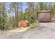 Property featuring two sheds and mature trees that is surrounded by greenery at 12191 Tecumseh Trl, Conifer, CO 80433