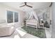 Bedroom featuring a white crib, nature-themed wallpaper, and plenty of natural light at 5668 Red Fern Ct, Littleton, CO 80125