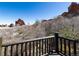 Deck featuring a rustic wood railing with views of the nearby mountains and trees at 5668 Red Fern Ct, Littleton, CO 80125