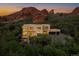 Stunning home nestled in a lush, green landscape, with beautiful red rock formations serving as a scenic backdrop at sunset at 5668 Red Fern Ct, Littleton, CO 80125