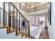 Inviting foyer with staircase featuring wood treads and black metal railings at 5668 Red Fern Ct, Littleton, CO 80125