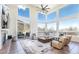 Bright living room features a wall of windows, a cozy fireplace and access to an outdoor patio with scenic views at 5668 Red Fern Ct, Littleton, CO 80125