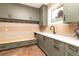Spacious mudroom features built-in bench, hooks, earth tone cabinets, counter space with sink, and large window at 5668 Red Fern Ct, Littleton, CO 80125