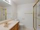 Bathroom featuring single sink vanity, a toilet and a standing shower with glass doors and gold trim at 86 Woodland Cir, Highlands Ranch, CO 80126