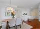 Dining area with neutral chairs and hardwood floors adjacent to a view of the kitchen at 86 Woodland Cir, Highlands Ranch, CO 80126