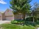 Charming brick home featuring a manicured lawn and mature trees, providing curb appeal and a welcoming atmosphere at 86 Woodland Cir, Highlands Ranch, CO 80126