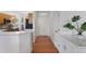 Bright hallway features hardwood floors and flows seamlessly towards a modern kitchen with white counters and wood cabinets at 86 Woodland Cir, Highlands Ranch, CO 80126