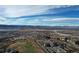 Scenic aerial view of a residential area with mountains in the distance and golf course in foreground at 3075 Greensborough Dr, Highlands Ranch, CO 80129
