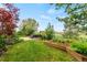 Well-manicured backyard with lush lawn, mature landscaping, and an inviting outdoor sitting area at 3075 Greensborough Dr, Highlands Ranch, CO 80129