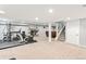 Finished basement with home gym, living area, fireplace, and staircase, perfect for recreation and relaxation at 3075 Greensborough Dr, Highlands Ranch, CO 80129