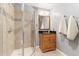 Cozy bathroom featuring a tiled shower with a glass door and a wood vanity with a black countertop at 3075 Greensborough Dr, Highlands Ranch, CO 80129