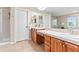 Bathroom features double sinks with wooden cabinetry, tile floors, and separate shower at 3075 Greensborough Dr, Highlands Ranch, CO 80129