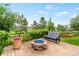 Beautiful backyard patio featuring a stone fire pit with glass, a comfy seat and colorful garden area at 3075 Greensborough Dr, Highlands Ranch, CO 80129