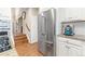 Modern kitchen showcasing stainless steel refrigerator, white cabinetry and hardwood floors at 3075 Greensborough Dr, Highlands Ranch, CO 80129