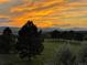 Scenic view of golf course with mature trees and the distant mountain range at sunset at 3075 Greensborough Dr, Highlands Ranch, CO 80129