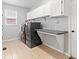 Functional laundry room with white cabinets, countertop space, and modern washer and dryer at 3075 Greensborough Dr, Highlands Ranch, CO 80129