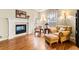 Living room with a cozy leather chair and ottoman next to the fireplace with wood floors at 3075 Greensborough Dr, Highlands Ranch, CO 80129