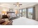 Spacious main bedroom with ceiling fan, sitting area, and sliding glass door to balcony at 3075 Greensborough Dr, Highlands Ranch, CO 80129