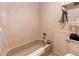 Bathroom featuring bathtub with tile surround, shower head, and decorative wainscotting at 7682 S Cove Cir, Centennial, CO 80122