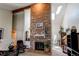 Spacious living room with a striking brick fireplace, vaulted ceilings, and ample natural light at 7682 S Cove Cir, Centennial, CO 80122