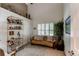 Bright living room boasts vaulted ceilings, plantation shutters, and stylish shelving with unique decor and art at 7682 S Cove Cir, Centennial, CO 80122