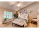 Bright main bedroom with bench seating, large windows, ceiling fan and ensuite bathroom at 7682 S Cove Cir, Centennial, CO 80122