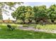Scenic park featuring lush green grass, mature trees, walking paths, benches, and picnic tables at 7682 S Cove Cir, Centennial, CO 80122