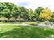 Scenic park featuring lush green grass, mature trees, walking paths, picnic tables and benches at 7682 S Cove Cir, Centennial, CO 80122