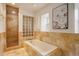 Luxurious bathroom featuring a soaking tub, glass block window, and tiled walk-in shower at 13200 E 160Th Ave, Brighton, CO 80602