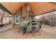 Covered patio features an outdoor kitchen with a grill, sink, dining area, and stylish lighting at 13200 E 160Th Ave, Brighton, CO 80602