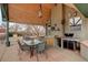 Covered patio features an outdoor kitchen with a grill, sink, dining area, and stylish lighting at 13200 E 160Th Ave, Brighton, CO 80602