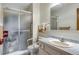 Clean bathroom featuring a shower with glass doors, updated fixtures, and tiled floor at 12565 Sheridan Blvd # 105, Broomfield, CO 80020