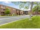 Brick condominium building featuring balconies, a glass entryway, and a well-maintained green lawn at 12565 Sheridan Blvd # 105, Broomfield, CO 80020