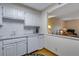 A bright kitchen featuring white cabinets, a dishwasher, and an open view to the living area at 12565 Sheridan Blvd # 105, Broomfield, CO 80020