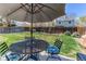 Relaxing backyard with a patio set under an umbrella and a lush green lawn at 8463 Wheatgrass Cir, Parker, CO 80134