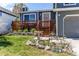 Charming home featuring a wood deck, landscaped yard, and decorative yard art at 8463 Wheatgrass Cir, Parker, CO 80134