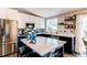 Well lit kitchen with a stainless fridge, white cabinets, a blue island, and colorful backsplash tiling at 8463 Wheatgrass Cir, Parker, CO 80134