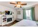 Comfortable bedroom with a decorative fireplace, built in shelving, and large windows with natural light at 8463 Wheatgrass Cir, Parker, CO 80134