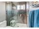 Sleek shower features glass doors and a tiled accent wall with grab bar at 8463 Wheatgrass Cir, Parker, CO 80134