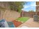 Cozy backyard featuring a small grassy area, concrete patio, and a chair with patterned cushions at 5573 S Lowell Blvd, Littleton, CO 80123