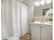 Clean bathroom featuring a shower-tub combo with white curtain, vanity, and tile flooring at 5573 S Lowell Blvd, Littleton, CO 80123
