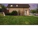Charming brick two-story home with a well-maintained lawn and lush green bushes and trees at 5573 S Lowell Blvd, Littleton, CO 80123