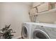 Functional laundry room with side-by-side washer and dryer, plus convenient overhead shelving at 5573 S Lowell Blvd, Littleton, CO 80123